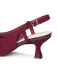 Close-up of the adjustable slingback strap, gold buckle and burgundy flared heel