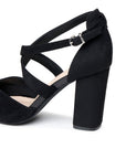 Close-up of the adjustable buckle, cross straps and black microsuede block heel
