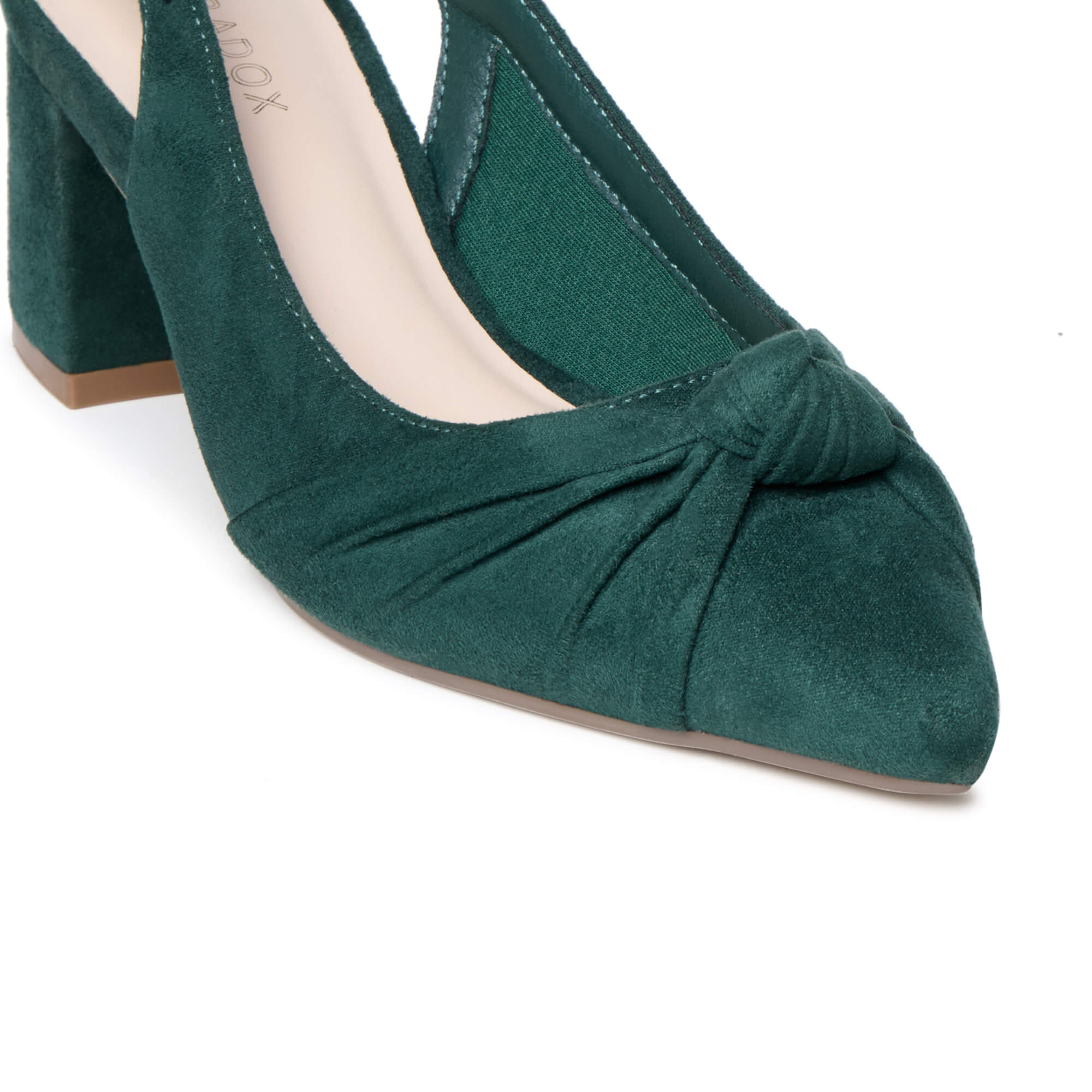 A close-up of a dark green suede pump shoe with a pointed toe, gathered front detail, and block heel on a white background.