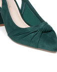 A close-up of a dark green suede pump shoe with a pointed toe, gathered front detail, and block heel on a white background.