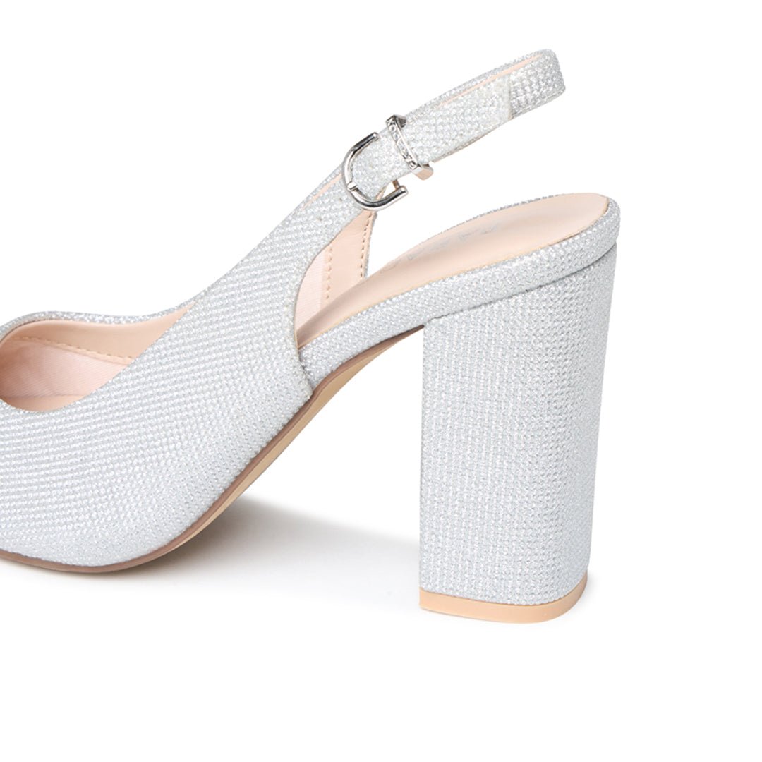 Close-up of the silver glitter block heel and adjustable slingback buckle