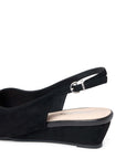 A close-up side view of a black wedge slingback sandal with a suede-like finish and a silver-tone buckle, shown on a plain white background.
