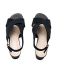 A pair of black slingback wedge sandals with wide crisscross straps and a glittery textured toe cap, shown from a top-down view on a white background.